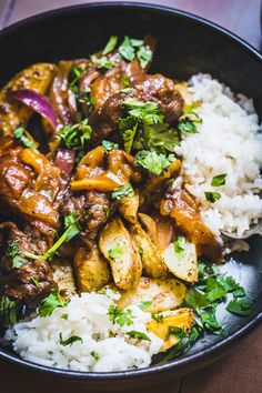 a bowl filled with rice, meat and veggies on top of a table