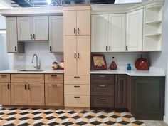 a kitchen with white cabinets and black and yellow checkered flooring on the tile