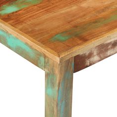 an old wooden table with green paint on the top and bottom edge, against a white background