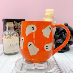 All orders are made to order and take a 2-4 week processing time  👻This Orange Ghost Ceramic Coffee mug is handmade and perfect for the coffee or tea lover in your life!  👻It is unique handmade pottery mug with a tan stoneware cone 6 clay.  👻The Ghosts are a clear cone 6 glaze with an Orange over glaze on top that protect the cone 6 stoneware underneath making the mug dishwater safe.  👻Dishwasher safe.  👻Microwave safe.  👻lead free and food safe glaze used.  👻 16 fluid ounce mug is 105 mm Autumn Mugs, Ghost Ceramic, Halloween Tea Party, Fall Mug, Cute Autumn, Mug Handmade, Autumn Gifts, Fall Gifts, Pottery Mugs