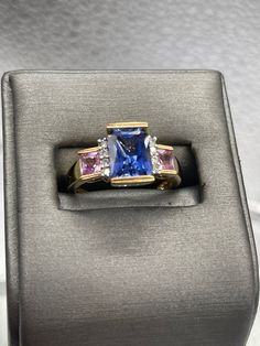 A beautiful ladies multi-gemstone ring designed and made in 10 karat solid yellow gold.  Set with a 2.5 carat rectangular cut Tanzanite stone bordered on each side with four fine white round Diamonds and two princess cut Pink Topaz set one on each side. This is an unusual composition of colored stones that always looks amazing and drips with sparkle. Weight:  4.2 grams Size:  7 ½  Our Price $595.00 Regularly Priced At $900.00 Please See Our Video Remember - If you're purchasing for yourself or a Emerald Cut Multi-stone Sapphire Ring With Diamonds, Formal Rectangular Sapphire Ring Fine Jewelry, Formal Rectangular Sapphire Ring, Classic Multi-stone Sapphire Ring With Baguette Cut, Formal Multi-stone Emerald Cut Sapphire Ring, Luxury Sapphire Ring With Rectangular Center Stone, Luxury Rectangular Diamond Ring With Accent Stones, Emerald Cut Three Stone Birthstone Ring For Formal Occasions, Formal Three-stone Emerald-cut Birthstone Ring