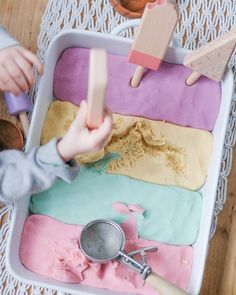 a child playing with play dough in a tray