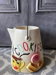 a ceramic tea pot with the word cookies written on it