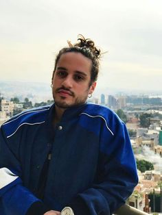 a man with dreadlocks on top of a building