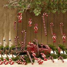 candy canes and christmas decorations on display in front of a fence