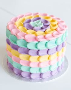 a multicolored cake sitting on top of a white table