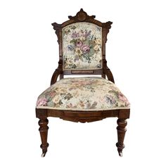 an old fashioned chair with floral upholstered back and arm rests against a white background