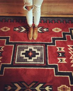 a woman standing on top of a red rug