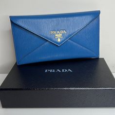 Just Purchased In Italy This Is A Gorgeous Prada Slim Envelope Wallet In Cobalt Blue Leather! Can Also Be Used As A Clutch. Stunning!!!!!! Gold Hardware. Fits Credit Cards And Perfect To Hold Cash Or Receipts. Has A Zip Pocket On The Back For Coins. Comes With Box And Authenticity Certificate. Makes A Gorgeous Gift! All Brand Brand New!! Super Pretty! Blue Is Even More Beautiful In Person. Designer Blue Bags With Card Slots, Blue Designer Bags With Card Slots, Modern Blue Clutch For Formal Occasions, Formal Blue Bags With Card Slots, Classic Blue Bag With Original Box, Formal Pouch Clutch With Original Box, Designer Blue Leather Clutch, Luxury Blue Clutch For Travel, Designer Envelope Clutch For Travel