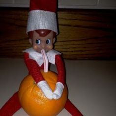 the elf is sitting on top of an orange