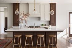 a kitchen island with three stools in front of it