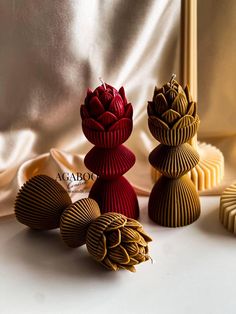 three decorative vases sitting next to each other on a white tablecloth covered surface