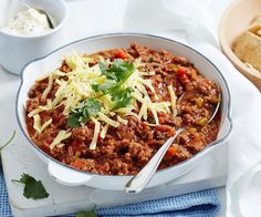 a white bowl filled with chili and cheese