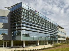 an office building with many windows on the front and side of it's facade