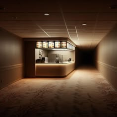 an empty room with lights on the ceiling and some food in glass cases behind the counter