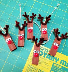 three reindeer made out of wood sticks on a cutting board with string attached to them