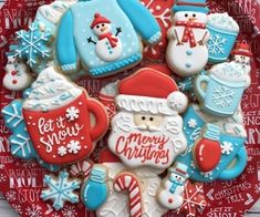 decorated cookies in the shape of santa claus and snowmen on a red platter