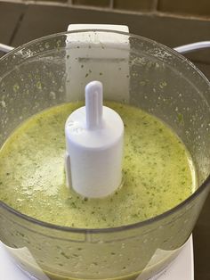 a blender filled with green liquid on top of a counter