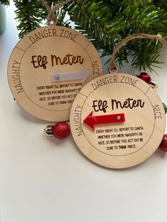 two personalized wooden christmas ornaments hanging from a tree