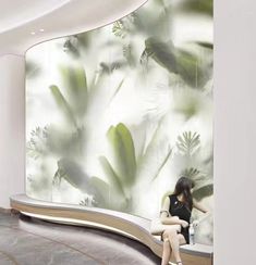 a woman is sitting on a bench in front of a wall with plants painted on it