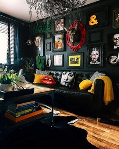 a living room with black walls and pictures on the wall, including an animal head