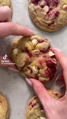 someone is holding a cookie with cranberries and almonds