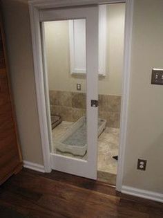 an open door leading to a bathroom with a bathtub on the floor in front of it