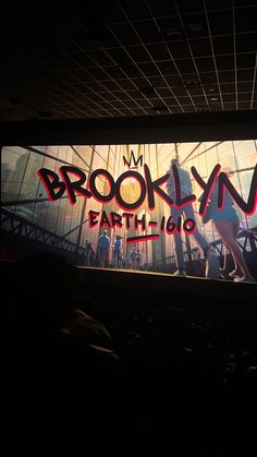 an advertisement for the brooklyn earth tour is projected on a large screen in a darkened room