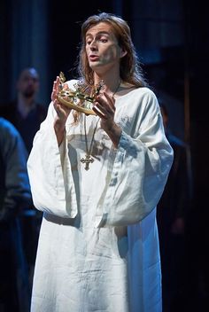 a man dressed in white is holding a piece of food and looking up at the sky