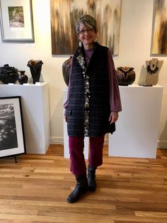 a woman standing in front of some art on display