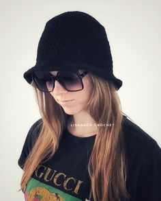 a woman with long hair wearing a black hat and t - shirt that says gucci