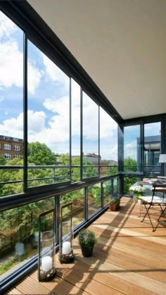 a balcony with wooden floors and large windows