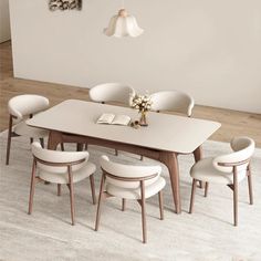 a dining room table with white chairs around it