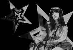 a black and white photo of a woman sitting in front of an abstract background with stars