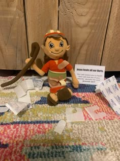 a stuffed monkey is sitting on the floor with some papers all over it's surface