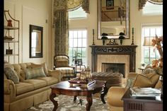 a living room filled with furniture and a fire place in front of a mirror on the wall