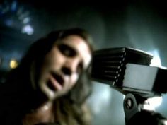 a man with long hair is singing into a microphone