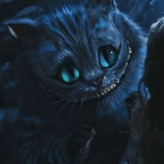 a close up of a cat with blue eyes and fangs on it's face