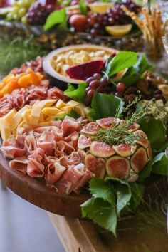 an assortment of meats and cheeses on a wooden platter