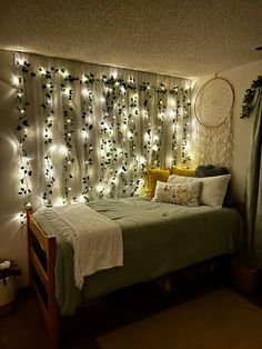 a bedroom with lights on the wall and a bed in front of a curtained window