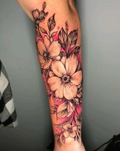 a woman's arm with flowers and leaves tattooed on the side of her leg