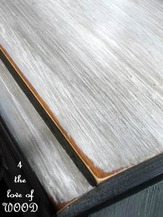 a close up of a wooden table with white paint on it and wood trim around the edges