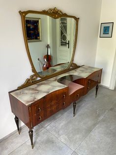 an antique vanity with marble top and mirror on the wall in front of a doorway