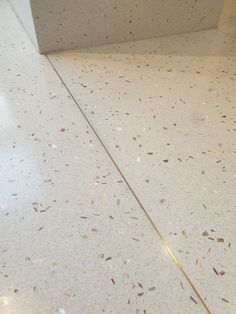 a white counter top sitting inside of a bathroom next to a toilet paper dispenser