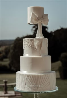 a white wedding cake with a bow on top