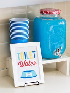 a blue mason jar sitting on top of a white shelf next to plates and cups