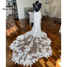 the back of a wedding dress on display at a bridal shop with mannequins in the background