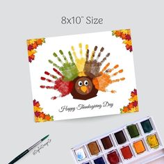 a card with a turkey on it next to watercolors and paintbrushes