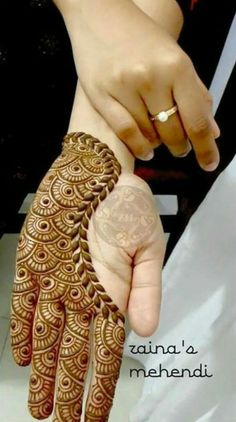 a person holding their hand with henna on it