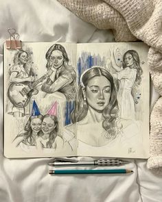 an open notebook with drawings of women on it and a pen resting next to it